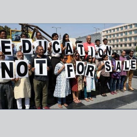 people holding sign that says "education not for sale"