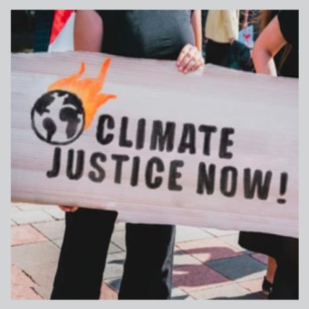Demonstrators holding a sign that says "climate justice now!"