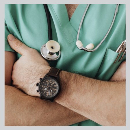 male doctor with folded arms, watch and stethescope